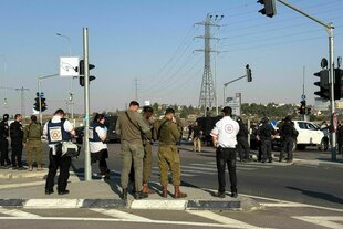 Soldaten und Polizist:innen stehen auf einer Kreuzung