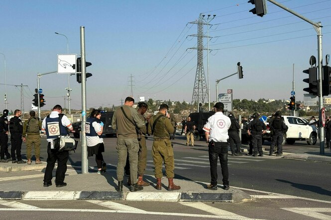 Soldaten und Polizist:innen stehen auf einer Kreuzung