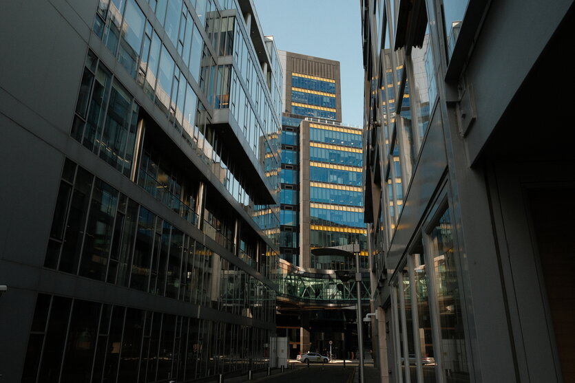 Blick auf ein Bürogebäude am Ende einer Straßenschlucht