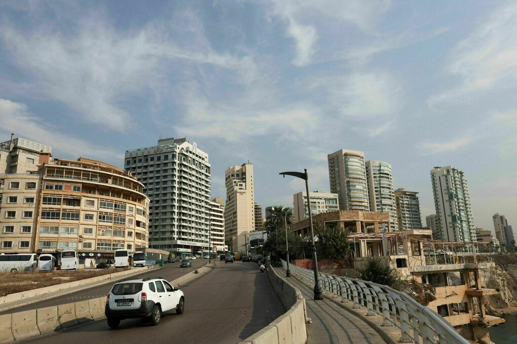 Ein Auto fährt auf einer Straße, im Hintergrund sind Hochhäuser zu sehen