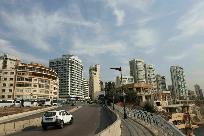 Ein Auto fährt auf einer Straße, im Hintergrund sind Hochhäuser zu sehen
