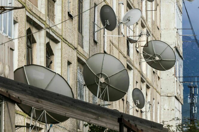 Satellitenschüsseln an der Fassade eines Wohnhauses