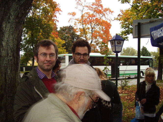 Die Musiker Jörg Hochapfel und Christoph Rothmeier im Freien am Rand eines Biergartens.