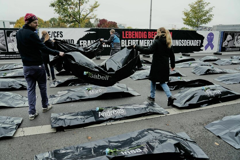 Menschen platzieren Leichensäcke auf einer Straße