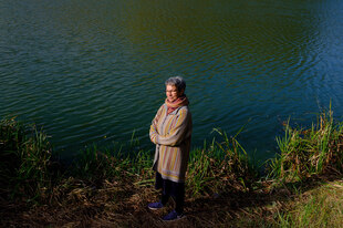 Eine Frau steht am Ufer eines Sees