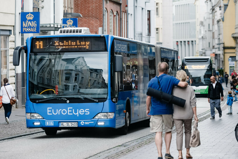Zwei Busse fahren hintereinander durch die Lübecker Altstadt