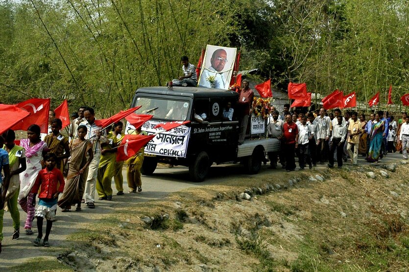 Trauermarsch mit roten Fahnen und einem Portrait des Maoistenführers Kanu Sanyal