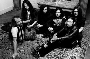 Can 1972 mit ihrem zweiten Sänger Damo Suzuki auf einem Teppich sitzend.