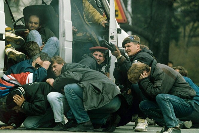 Menschen verstecken sich, während sie beschossen werden