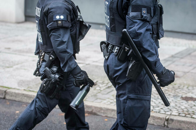 Zwei Polizisten mit Pfferspray und Schlagstock