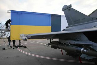 Eine ukrainische Flagge hinter einem Kampfjet.