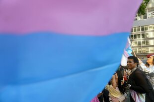 Eine große Fahne verdeckt Protestierende