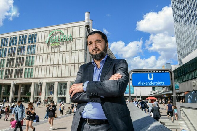 Ein Mann vor einem Kaufhaus auf dem Berliner Alexanderplatz