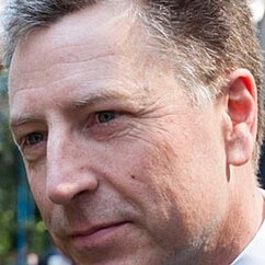 Der Diplomat trägt ein Sakko und hat kurze Haare