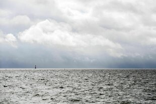 Der Leuchtturm Arngast steht bei bedecktem Wetter im Jadebusen