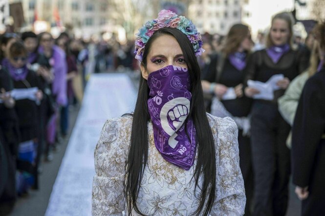 Eine vermummte Demonstrierende in einem weißen Brautkleid