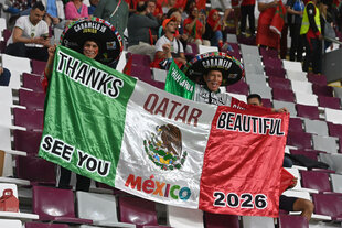 Zwei Fans mit Sombrero halten mexikanische Fahne hoch auf der steht: Thanks Quatar beautiful, see you Mexico 2026"