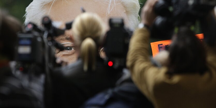 Journalisten vor Wahlplakat