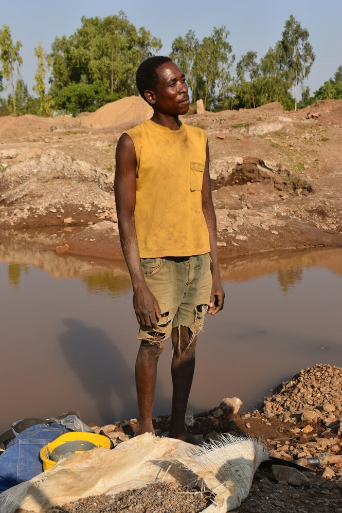 Ein Mann steht vor einem kleinen See und schaut in die Ferne