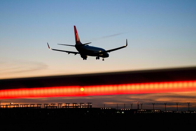 Ein Flugzeug bei Dämmerung über dem Horizont.