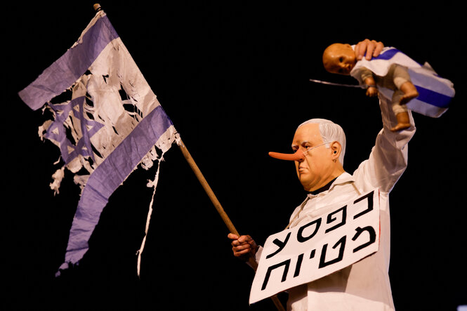 Ein Mann hat sich verkleidet als Bibi Netanjahu mit langer Nase und protestiert so in Tel Aviv