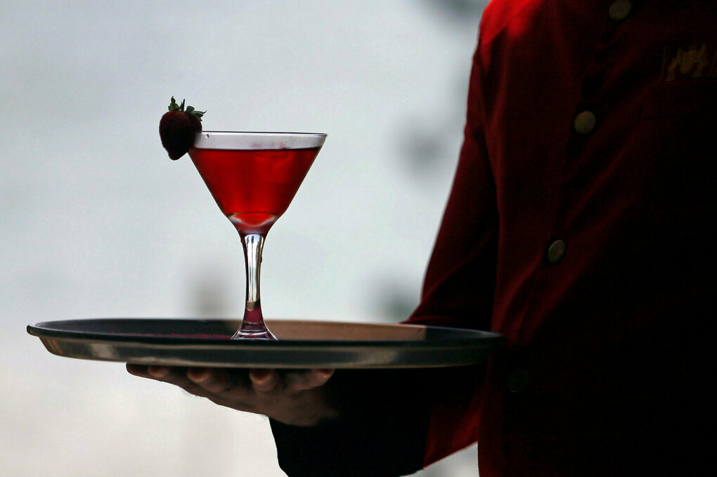 Jemand serviert einen roten Cocktail.