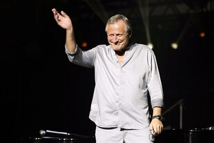 Konstantin Wecker winkt auf der Bühne dem Publikum zu