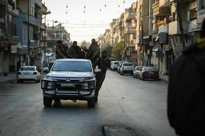Syrische Soldaten fahren auf einem Auto durch eine Straße