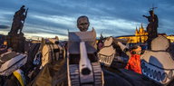 Menschen in Prag demonstrieren mit gebasteltem Putin-Kopf auf Panzern aus Pappe