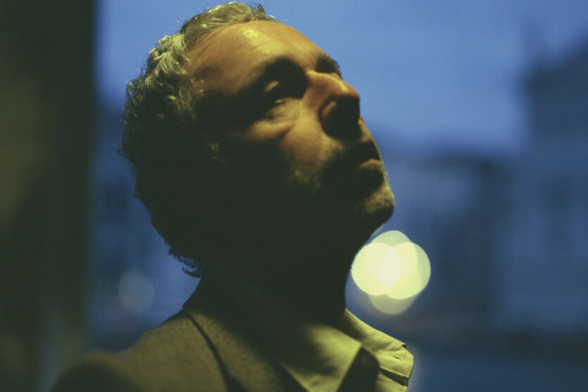 Baxter Dury im feinen Zwirn blickt in den Abendhimmel. Foto ist möglicherweise in Venedig entstanden.