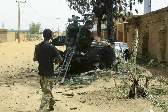 Ein Soldat geht auf einen Wagen mit einem zerstörten Geschütz zu