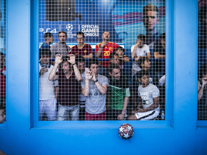 Fußballfans vor einem Gitter