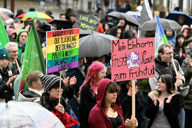 Menschen demonstrieren mit bunten Schildern gegen Rechtsextremismus