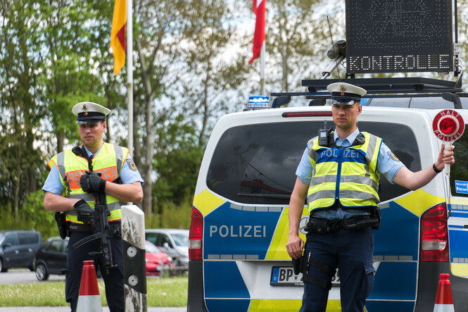 Bundespolizisten vor ihrem Fahrzeug, auf dessen Dach ein Display mit dem Wort 