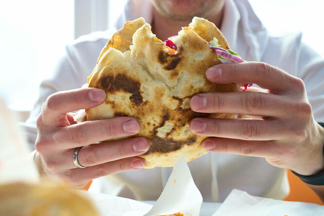 Zwei Hände halten einen Döner