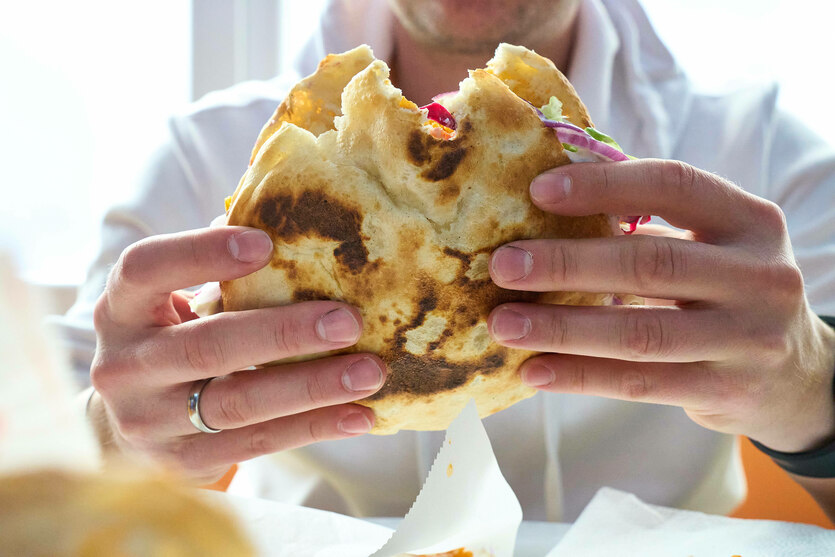 Zwei Hände halten einen Döner