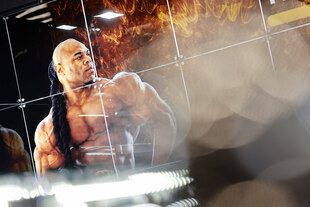 Ein muskulöser Bodybuilder guckt auf sein Spiegelbild