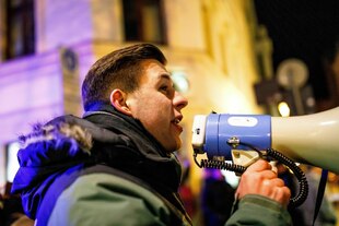 Jean-Pascal Hohm mit einem Megafon in der Hand - er trägt eine warme Jacke
