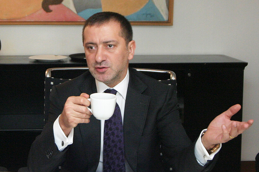 Foto von Fatih Altayli mit einer Tasse in der Hand.