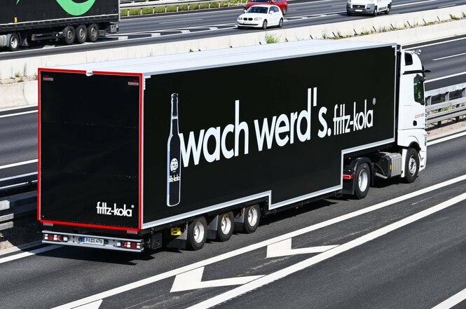 Ein Lkw mit Werbung für Fritz-Kola auf einer Autobahn.