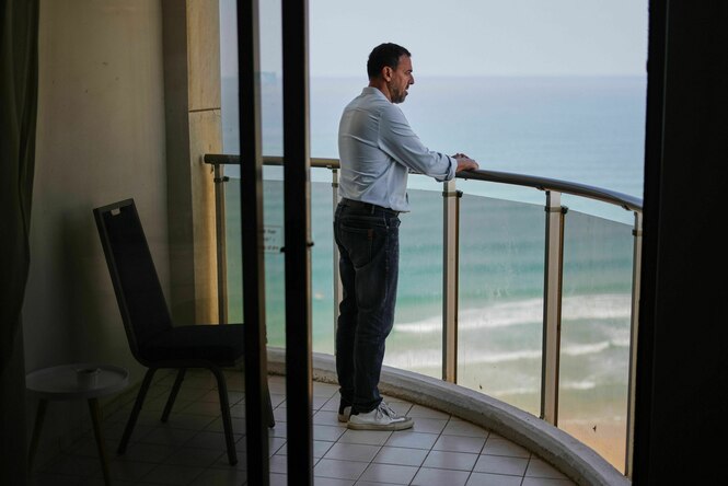 Porträt von Eli Sharabi auf einem Balkon mit Blick auf das Meer.