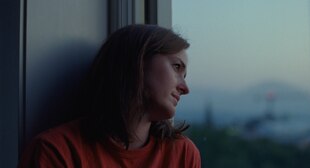 Eine Frau blick sehnsüchtig aus einem Fenster