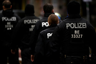 Fünf Polizisten laufen hintereinander