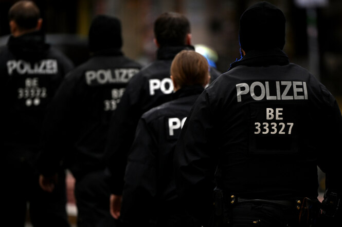 Fünf Polizisten laufen hintereinander