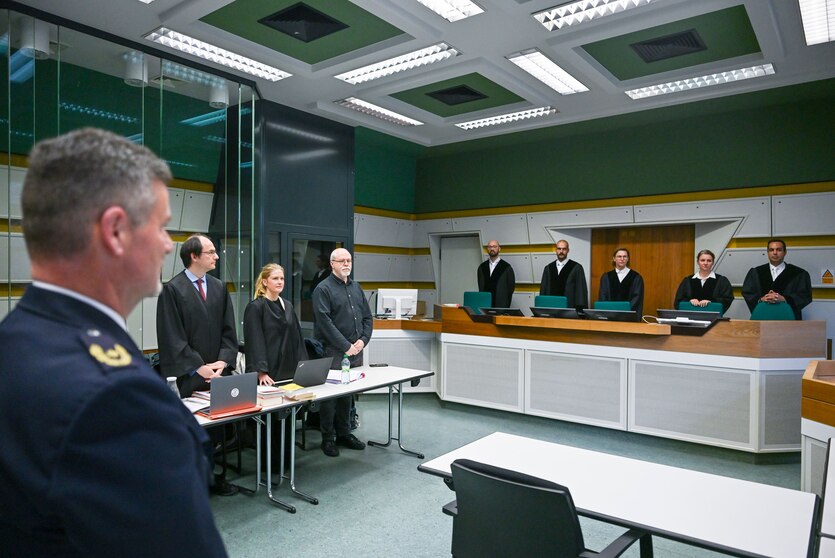 In einem Gerichtssaal im Kriminalgericht Moabit stehen der Zeuge Stephan Katte (l), Direktor bei der Polizei Berlin, und der Kläger Wieland Hoban (4.v.l), Vorsitzender von „Jüdische Stimme“, mit seinen Anwälten.