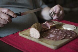 Eine Person sitzt an einem Tisch und ist Wurst