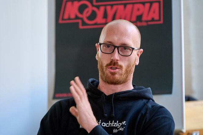 Christoph Harting, Olympiasieger von 2016 sitzt vor einem Plakat mit der Aufschrift «NOOLYMPIA». Das Berliner NOlympia-Bündnis erläutert seine Vorstellung zum angestrebten Volksentscheid