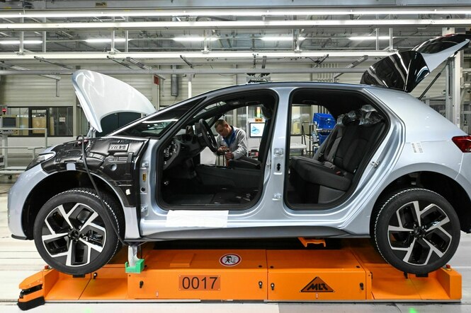 Ein Auto steht auf einer Montagelinie imWerk von Volkswagen - das Auto hat noch keine Türen oder Fenster, der Kofferraum steht offen