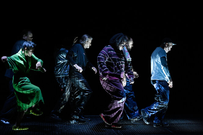 Mehrere Personen bewegen sich im Dunkeln hintereinander