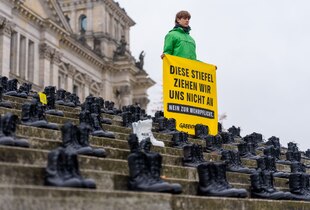 Aktivisten von „Greenpeace“ haben Bundeswehrstiefel mit der Aufschrift „Nein zur Wehrpflicht“ vor dem Bundestag aufgestellt.